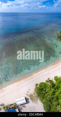 Ein vertikales Luftpanorama des Gun Beach am nördlichen Ende der Tumon Bay auf der Insel Guam, Mikronesien. Der gerade, markante Schnitt durch die Stockfoto