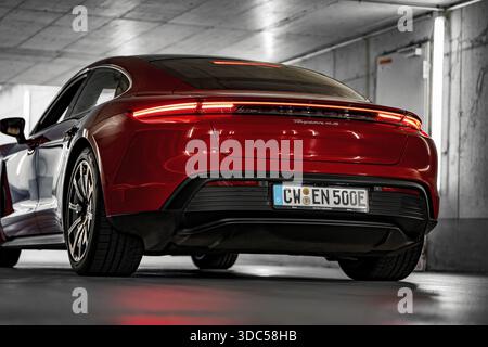 Rotes Auto in einer unterirdischen Garage, moderne Beleuchtung, sportliches Heck, Porsche Taycan, Deer Carsharing, Calw, Deutschland Stockfoto