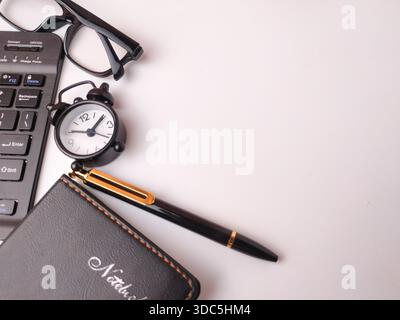 Das Bild zeigt eine Sammlung von Büroartikeln, die als flache Lage auf weißem Hintergrund angeordnet sind. Stockfoto