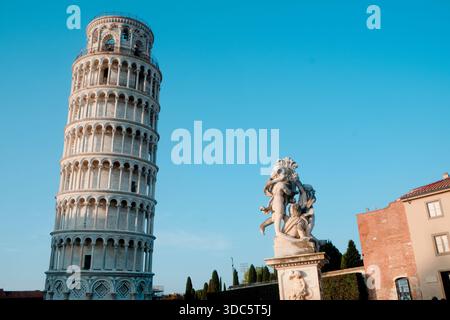 Pisa, Italien - 26. Juni 2025: Der schiefe Turm von Pisa steht links, während der Marmor-Cherub-Brunnen auf der rechten Seite des Rahmens leuchtet Stockfoto