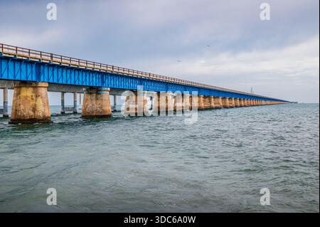 Weitwinkelblick auf die Seven Mile Bridge, die an einem bewölkten Tag am Horizont verschwindet, The Keys, Florida Stockfoto