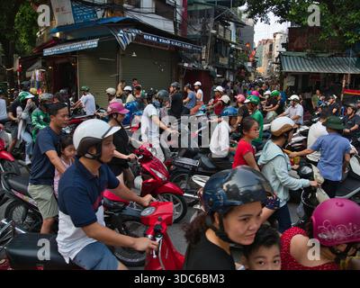 hanoi-Vietnam-10. August 2019, dichte Verkehrsstaus mit zahlreichen Motorrädern und Motorrollern, die Eisenbahngleise in einem geschäftigen Stadtgebiet von Hano überqueren Stockfoto
