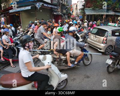 hanoi-Vietnam-10. August 2019, dichte Verkehrsstaus mit zahlreichen Motorrädern und Motorrollern, die Eisenbahngleise in einem geschäftigen Stadtgebiet von Hano überqueren Stockfoto