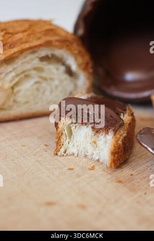 Nahaufnahme eines Croissantstücks mit Schokoladenaufstrich Stockfoto