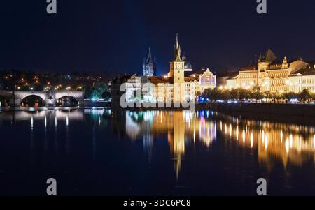 Erkunden Sie das bezaubernde Prag, Tschechien, bei Nacht. Dieses atemberaubende Bild zeigt die beleuchtete Skyline, die berühmte Karlsbrücke und die Moldau und fängt den Zauber der Stadt ein. Stockfoto