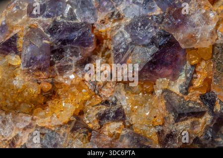 Diese Szene zeigt ein großes Gesteinsfragment mit Quarz- und Fluoritkristallen. Reflexionen und Farben von Mineralien erregen Aufmerksamkeit in der natürlichen Umgebung. Stockfoto