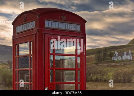 179 Rote Telefonzelle neben der A855 im Dorf Brogaig am Fuße der Quiraing-Landform, altes K6-Modell noch in Betrieb. Skye-Scotland. Stockfoto