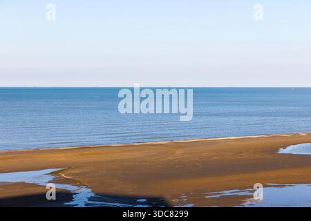 Friedliche Meereslandschaft mit sandiger Küste, ruhigem Meer und blauem Himmel, die ein entspannendes und ruhiges Küstenambiente bietet. Küste des Kaspischen Meeres, Buzowna Stockfoto