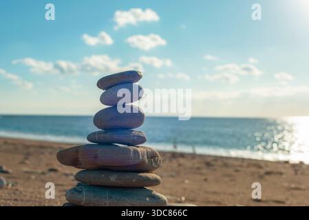 Balancieren von Steinen am Meer. Sommerferienkonzept. Stockfoto