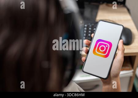 Ein nicht erkennbarer weiblicher Teenager hält ein Handy mit dem Instagram-Logo auf dem Bildschirm Stockfoto