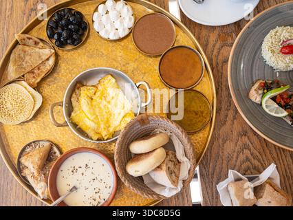 Traditionelles marokkanisches Frühstück auf einem Blech aus Messing mit Eiern, Fladenbrot, Oliven, Käse, Gebäck, Tee und Kaffee. Authentische nordafrikanische Küche Stockfoto