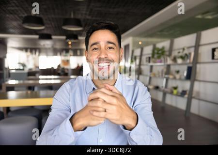 Glücklicher lateinamerikanischer Blogger, der im Online-Konferenz-Chat spricht Stockfoto