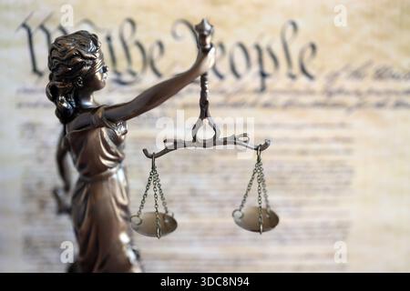 Die Statue der Gerechtigkeit Themis, die Göttin der Gerechtigkeit mit den Augen gegen die US-Verfassung Seite. Urteil und Strafe in den Vereinigten Staaten Stockfoto