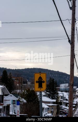 Kanada, Québec, 27. November 2025: Warnschild für Hydranten in verschneiten Wohnvierteln, Winterlandschaft, bedeckter Himmel Stockfoto