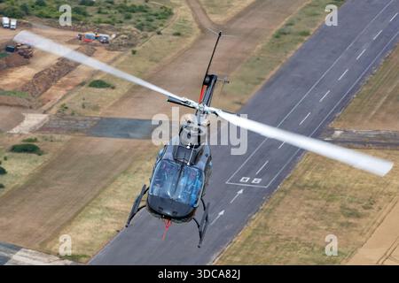 Das Bild zeigt einen Bell 206B JetRanger III Hubschrauber, der als D-HHFW registriert und von Heliteam betrieben wird. Es wird während einer Air-to-Air-Session beim Royal International Air Tattoo in der Nähe von Fairford, England, fotografiert. Der Bell 206B ist ein leichter einmotoriger Hubschrauber, der weit verbreitet für Dienstleistungs- und Supportaufgaben eingesetzt wird. Das Rotorsystem, das Fahrwerk und die äußeren Markierungen des Flugzeugs sind in dieser Luftaufnahme deutlich sichtbar. Stockfoto