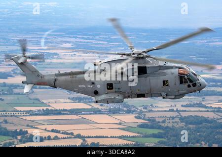 Dieses Bild zeigt einen Hubschrauber der Royal Navy EHI EH101 und EH101-111 Merlin HM2 mit der Registrierung ZH832, der bei der Royal International Air Tattoo in Fairford, England, Air-to-Air-Flug durchführt. Das Flugzeug zeigt Multifunktionsfähigkeit, Präzisionsflug, Agilität, Pilotenkontrolle und operative Leistung. Die Ausstellung zeigt die moderne britische Militärflugtechnik und die Rolle der EH101-Hubschrauber bei Transport-, Unterstützungs- und Suchoperationen auf einer internationalen Flugschau. Stockfoto