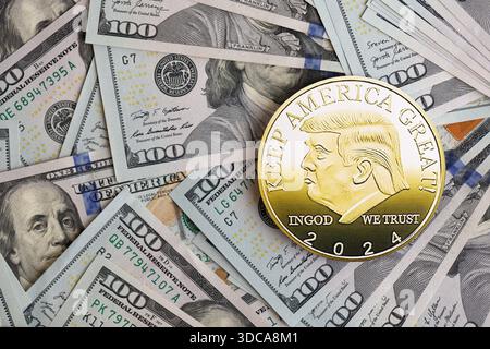 KIEW, UKRAINE - 13. DEZEMBER 2025 Trump Goldmünze auf großen Mengen von US-Dollar-Banknoten Stockfoto