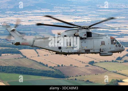 Ein Hubschrauber der Royal Navy EHI EH101-111 Merlin HM2 mit der Zulassung ZH832 wurde während des Royal International Air Tattoo bei der RAF Fairford, England, Air-to-Air fotografiert. Der Merlin HM2 wird für Transport-, Such- und Rettungseinsätze sowie für den Seeverkehr eingesetzt. Die Abbildung zeigt die Rumpf-, Rotorsystem-, Heck- und Betriebsmarkierungen. Das Foto dokumentiert die Konfiguration des Hubschraubers, die Missionsrolle und die Flughaltung während der Flugschau. Stockfoto