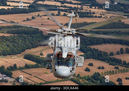 Ein Helikopter der Royal Navy EHI EH101-111 Merlin HM2 mit der Zulassung ZH832 wird während einer Air-to-Air-Session bei der Royal International Air Tattoo über Fairford, England, gefangen genommen. Der Merlin HM2 ist ein Mehrzweck-Helikopter, der für U-Boot-Kriegsführung, Überwachung und Versorgungsmissionen eingesetzt wird. Die Abbildung zeigt Hauptrotor, Heckrotor, Rumpf, Cockpit und Royal Navy Markierungen. Stockfoto