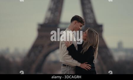 Ein romantisches Paar umarmt Paris Frankreich mit dem Eiffelturm im Hintergrund. Dieses Bild eignet sich für Reise- und Tourismuswerbung Valen Stockfoto