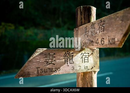 Raditionales hölzernes Wegweiser auf dem malerischen Nakasendo-Wanderweg zwischen den historischen Poststädten Magome und Tsumago aus der Edo-Zeit. Stockfoto