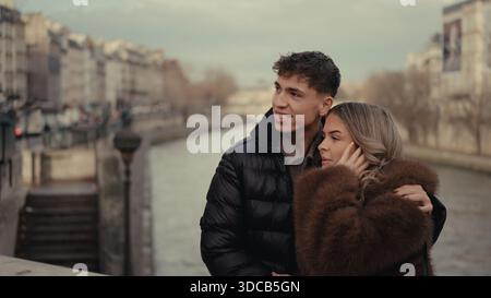 Ein romantisches Paar umarmt sich auf einer Brücke über die seine in Paris Frankreich mit einem Stadtbild Hintergrund. Dieses Bild eignet sich für Reisen und Tourismus Stockfoto