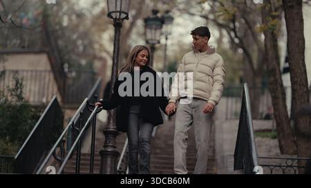 Ein romantisches Paar hält Händchen, während er in Montmartre Paris Frankreich die Treppe hinuntergeht. Der junge Mann und die Frau sind verliebt und genießen ihren Urlaub Stockfoto