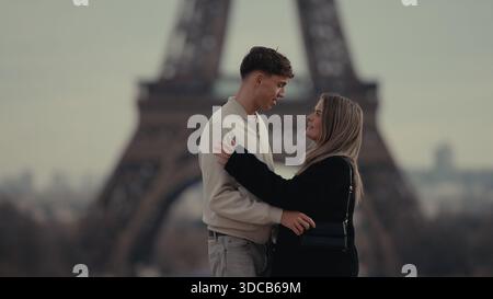 Ein romantisches Paar umarmt Paris Frankreich mit dem Eiffelturm im Hintergrund. Dieses Bild ist geeignet für Reise- und Tourismuskampagnen romantische G Stockfoto