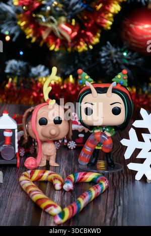 Funko Pop Actionfiguren von Mantis von Guardians of the Galaxy und Hund Max von How the Grinch Stolen Christmas. Weihnachtsbaum, Zug, Zuckerstangen. Stockfoto