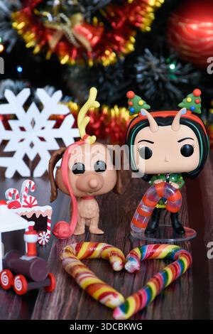 Funko Pop Actionfiguren von Mantis von Guardians of the Galaxy und Hund Max von How the Grinch Stolen Christmas. Weihnachtsbaum, Zug, Zuckerstangen. Stockfoto