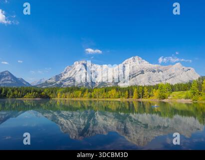 Ein Kajakfahrer, Herbstfarben und Reflektionen am Wedge Pond mit Mount Kidd im Hintergrund. Kananaskis Country, Alberta, Kanada. Stockfoto