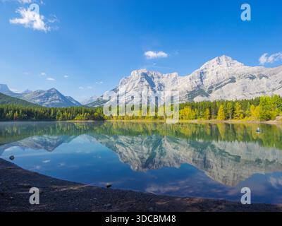 Ein Kajakfahrer, Herbstfarben und Reflektionen am Wedge Pond mit Mount Kidd im Hintergrund. Kananaskis Country, Alberta, Kanada. Stockfoto