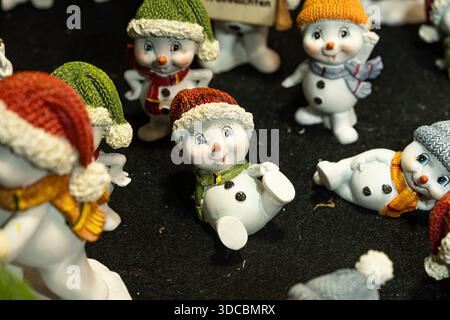 Niedliche Keramik-Schneemänner-Figuren auf dem Wiener Weihnachtsmarkt. 20. Dezember 2025, Wien, Österreich. Stockfoto