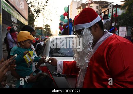 NAVI MUMBAII, INDIEN - 21. DEZEMBER: Die Mitglieder der Pfarrkirche St. Francis de Sales verbreiteten Weihnachtsfreude, indem sie Weihnachtslieder sangen, um den Weihnachtswagen mit dem Thema The Whole Earth is One Family in Kopar Khairane zu feiern, am 21. Dezember 2025 in Navi Mumbai, Indien. Foto: Bachchan Kumar/Hindustan Times die Menschen feiern Weihnachtsfest Stockfoto