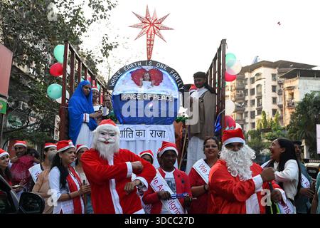 NAVI MUMBAII, INDIEN - 21. DEZEMBER: Die Mitglieder der Pfarrkirche St. Francis de Sales verbreiteten Weihnachtsfreude, indem sie Weihnachtslieder sangen, um den Weihnachtswagen mit dem Thema The Whole Earth is One Family in Kopar Khairane zu feiern, am 21. Dezember 2025 in Navi Mumbai, Indien. Foto: Bachchan Kumar/Hindustan Times die Menschen feiern Weihnachtsfest Stockfoto