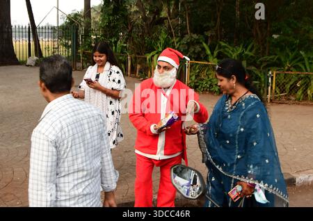 Mumbai, Indien. Dezember 2025. MUMBAI, INDIEN – 21. DEZEMBER: Gurucharan Singh Lucky, gekleidet in einem Weihnachtsmannskostüm, verteilt Schokolade an die Menschen vor dem Weihnachtsfest am 21. Dezember 2025 in Mumbai, Indien. (Foto: Bhushan Koyande/Hindustan Times/SIPA USA) Credit: SIPA USA/Alamy Live News Stockfoto