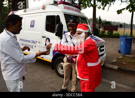 Mumbai, Indien. Dezember 2025. MUMBAI, INDIEN – 21. DEZEMBER: Gurucharan Singh Lucky, gekleidet in einem Weihnachtsmannskostüm, verteilt Schokolade an die Menschen vor dem Weihnachtsfest am 21. Dezember 2025 in Mumbai, Indien. (Foto: Bhushan Koyande/Hindustan Times/SIPA USA) Credit: SIPA USA/Alamy Live News Stockfoto