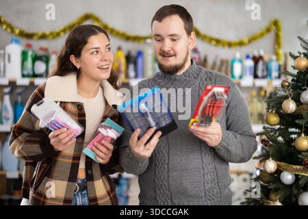 Ein Paar Mann und eine Frau, die Rasierer in einem dekorierten Laden wählen Stockfoto