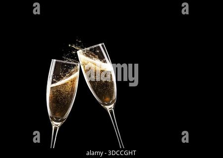Zwei Sektflöten, die bei einem festlichen Toast anstoßen. Goldene Blasen und Spritzer vor einem dramatischen schwarzen Hintergrund. Elegante Feier, Silvester oder W Stockfoto