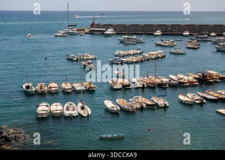 Kleine Boote, die in einem geschützten Yachthafen entlang der Amalfiküste unter klarem blauen Himmel vor Anker gehen. Stockfoto