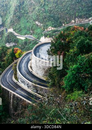 Blick auf die scharf gewundene Bergstraße auf dem Berg Tianmen in China, mit dramatischen Haarnadelkurven und steiler Panoramastraße, die zum berühmten Hang führt Stockfoto