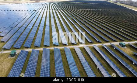 Luftaufnahme von Reihen von Solarpaneelen in einem großen Solarpark, der erneuerbaren Strom erzeugt Stockfoto