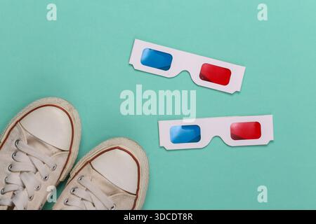 Old School Sneakers und Anaglyphen 3D Brille auf mintgrünem Hintergrund. Draufsicht Stockfoto