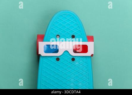 Anaglyphen-3D-Brille auf dem Kreuzbrett. Mintgrüner Hintergrund. Hipster-Outfit. Unterhaltung 80er Jahre Draufsicht Stockfoto