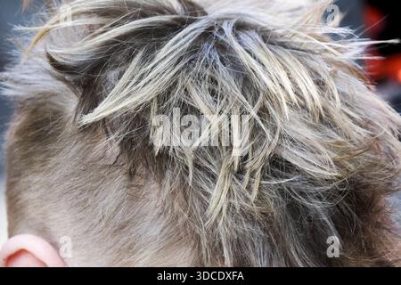 Nahaufnahme der blonden Männerfrisur mit verblassendem Schnitt und strukturiertem Oberteil mit modernem, trendigem Mode-Stil und unordentlichem Look, der legere Selbstvertrauen und ein lässiges Gefühl vermittelt Stockfoto