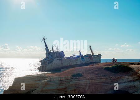 Paphos Zypern - 13. Dezember 2025: Rostiges Schiffswrack Edro III. Ist in der Nähe der felsigen Küste in Zypern gestrandet. Verlassenes Frachtschiff in ruhigem blauem Meer unter c Stockfoto