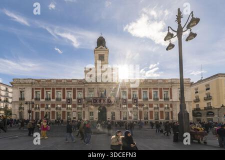Madrid, Spanien - 09. November 2016: Blick auf die berühmte Casa de Correos, die sich in der Sonne sonnt, mit der geschäftigen Puerta del Sol, die mit Menschen unter einem Zimmer lebt Stockfoto