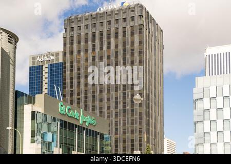 Madrid, Spanien - 09. November 2016: Blick auf das hoch aufragende OPALO-Gebäude, das in den Himmel ragt, eingerahmt vom pulsierenden Kaufhaus El Corte Inglés und dem Stockfoto
