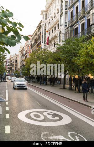 Madrid, Spanien - 09. November 2016: Blick auf die pulsierende Straßenszene auf der Calle de Alcalá, wo die Herbstbäume die Allee säumen und sich von der Farbe abheben Stockfoto