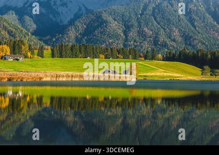 Blick auf den ruhigen See, der Berge und Bäume in Herbstfarben reflektiert, eine ruhige Szene der Schönheit der Natur, Krun, Bayern, Deutschland. Stockfoto